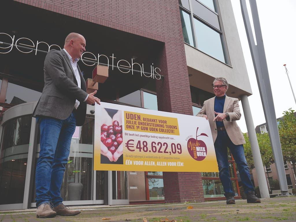 Ton van Summeren (penningmeester GoedeDoelenWeek Uden) presenteert de opbrengst aan Maarten Prinssen (wethouder gemeente Uden)